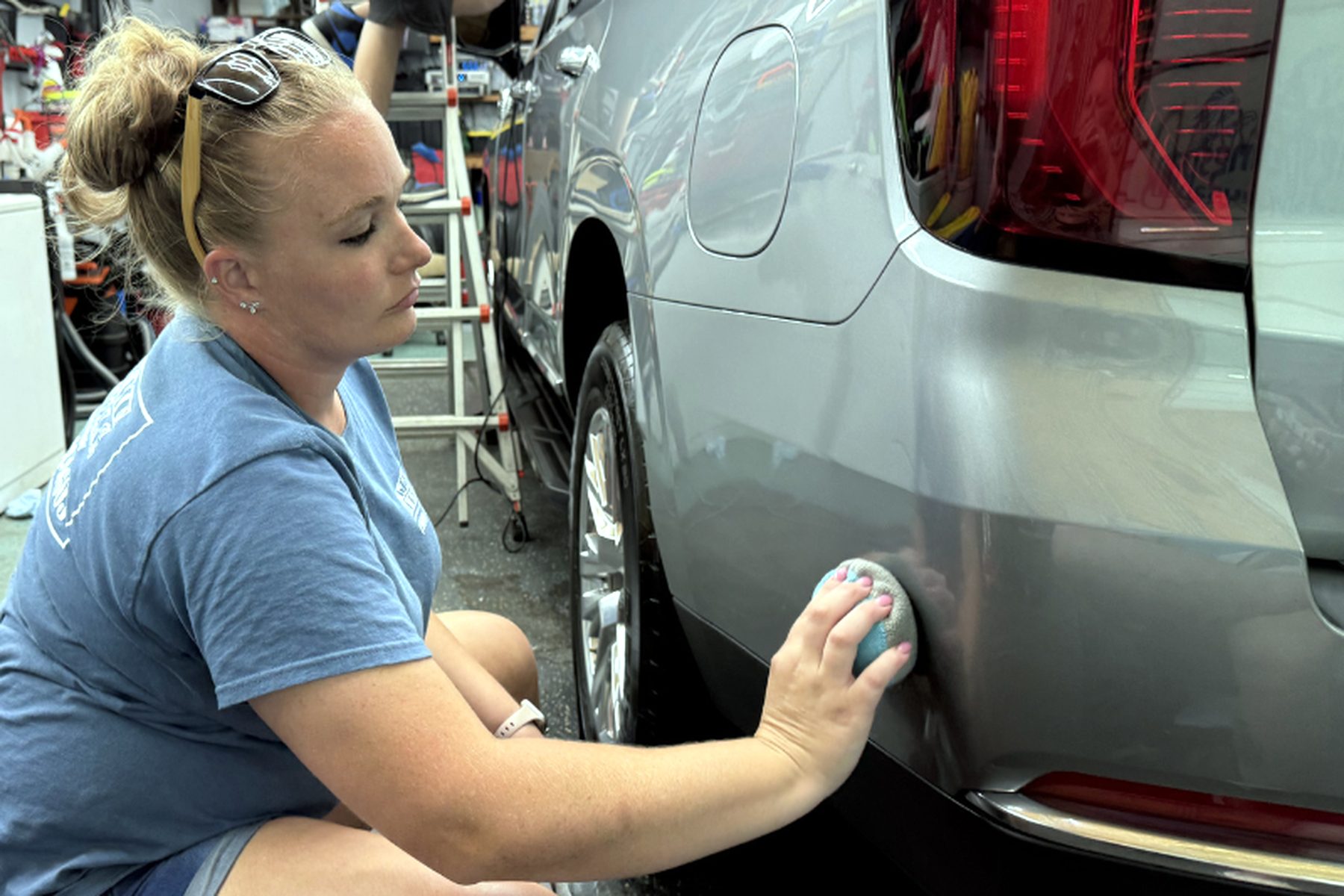 Wilmington Auto Detail technician hand-polishing the rear quarter of a silver SUV — car wax near me