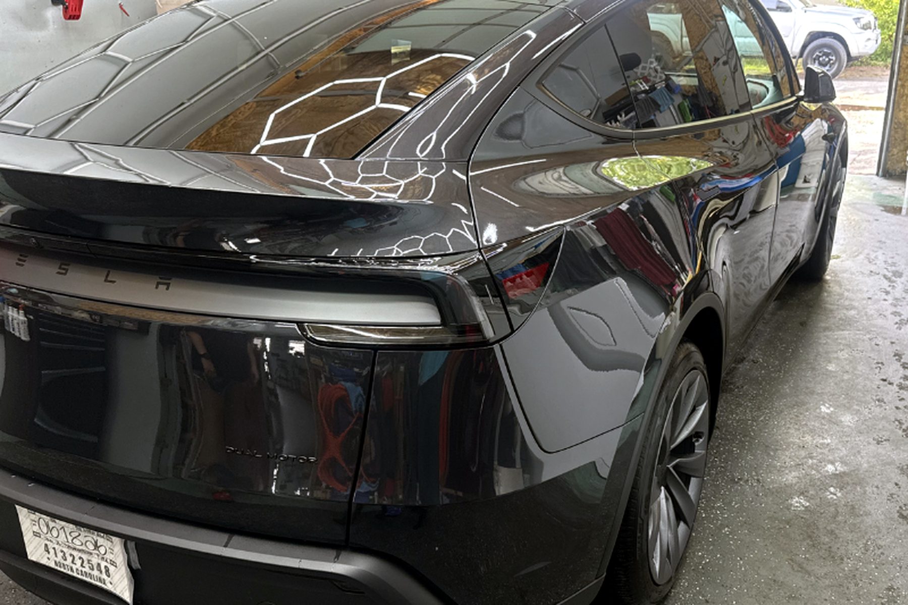 Glossy ceramic-coated Tesla Model Y parked outside the shop — ceramic coating Wilmington NC