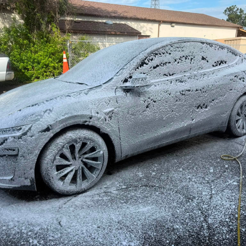 Tesla Model Y covered in snow foam during a hand wash