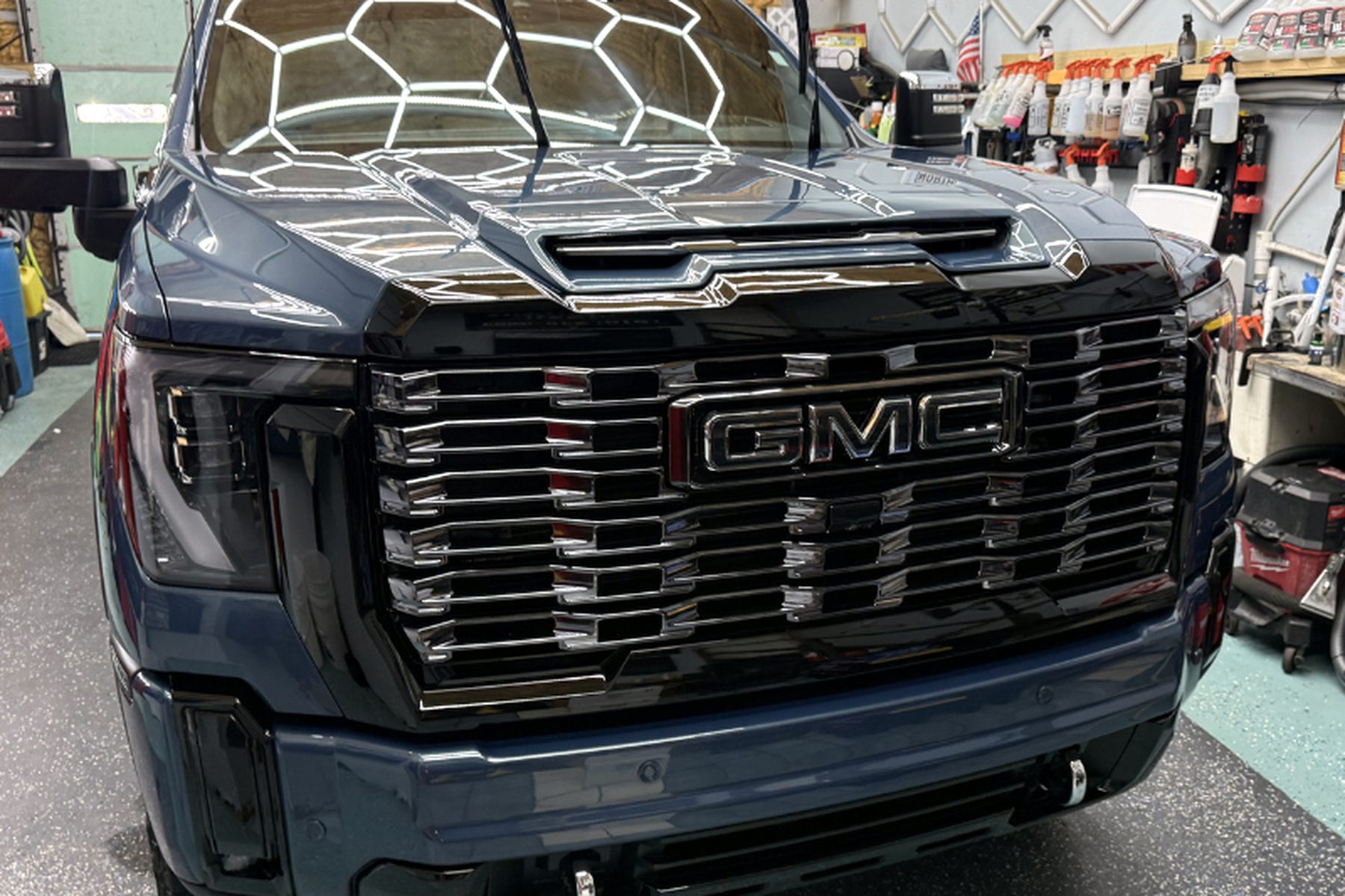 Glossy black GMC Denali truck inside the Wilmington Auto Detail bay after a full detail